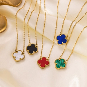 Detailed close-up of clover pendants in multiple colors displayed on yellow satin fabric