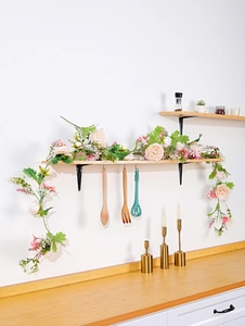 Detail of pink and cream silk rose vines draped on a wooden shelf for home decor