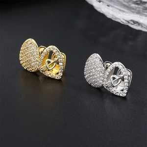 Macro detail of gold and silver heart-shaped hip hop grillz with micro-set cubic zirconia