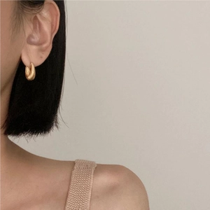 Elegant 925 sterling silver hoop earrings with gold-plated spiral texture on a female model