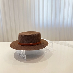 Minimalist brown flat top boater straw hat with leather belt strap for summer sun protection