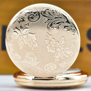 Close-up of vintage gold pocket watch featuring intricate floral relief carvings