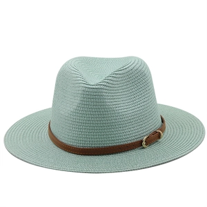 Detail of the mint green straw fedora hat featuring a brown leather belt decoration