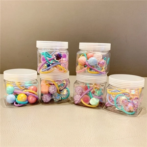 Detail of assorted colorful bead hair ties in clear jars with heart and star charms