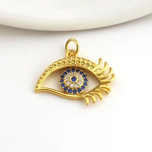 Macro detail of gold evil eye pendant featuring micro-paved blue and white cubic zirconia