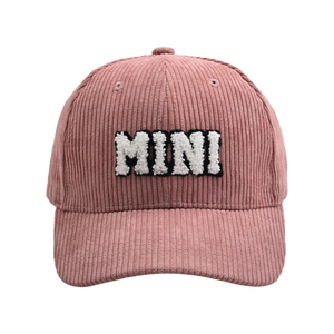 Detailed close-up of pink corduroy texture and white plush MINI embroidery on baseball cap