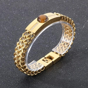 Detail of gold hip hop bracelet featuring tiger eye stone and diamond accents