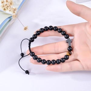 Detail of 8mm matte natural stone bracelet with cross charm and adjustable braided rope