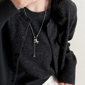 Collier minimaliste en argent avec pendentif cheval et zircon porté par un mannequin chic