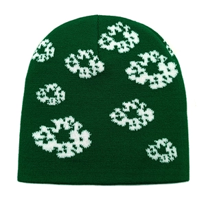 Detailed close-up of dark green knitted beanie featuring white floral jacquard patterns