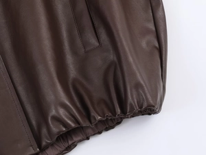 Detail of elastic hem and stitching on brown faux leather stand collar jacket