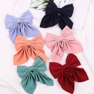 Flat lay of large multi-layered solid color bow hair clips in six vibrant aesthetic shades
