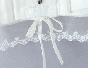 Gros plan sur la dentelle blanche avec tissu en mesh et nœud coulissant délicat