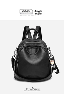 Detail view of black pebble leather backpack featuring multiple zippers and a small calf charm