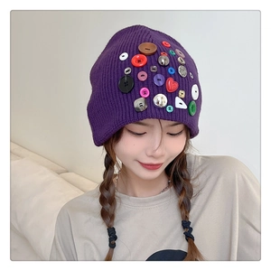 Detailed close-up of purple knit beanie featuring vibrant decorative colored buttons