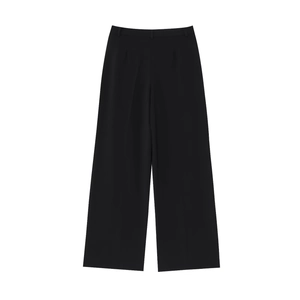 Détail du pantalon de costume noir à jambes larges avec taille haute et tissu drapé