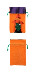 Detail of Halloween drawstring bag with green witch face and orange velvet texture