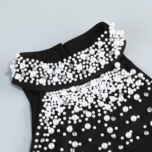 Close-up of elegant black evening dress featuring ornate pearls and rhinestone details