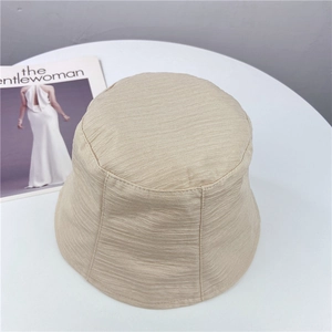 Vue de dessus d'un chapeau bob beige en tissu texturé sur une table blanche