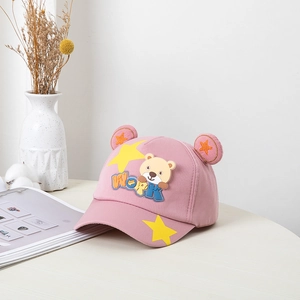 Casquette rose enfant avec oreilles d'ours et broderie WORK sur bureau minimaliste