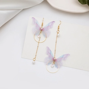 Détails de boucles d'oreilles asymétriques dorées avec ailes de papillon violettes et perles