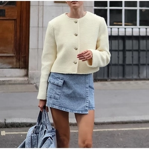Elegante giacca di lana color crema con scollo rotondo e gonna a portafoglio in denim