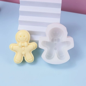 Gingerbread man silicone mold with finished candle on a pink and blue decorative background