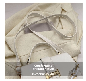 Detail of cream crossbody bag with golden buckle and white resin chain accent