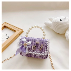 Detail of lavender tweed girl's handbag featuring pearl handle and bow decoration