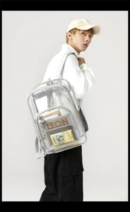 Detail of transparent PVC backpack showing side mesh pocket and gray strap reinforcement