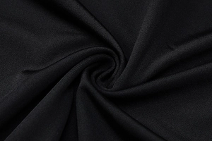 Close-up of black mesh fabric with a smooth texture and glossy finish for the dress