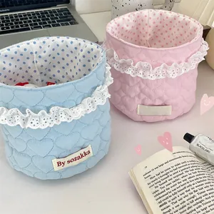 Detailed view of pink and blue quilted heart storage baskets with lace edges and dot lining