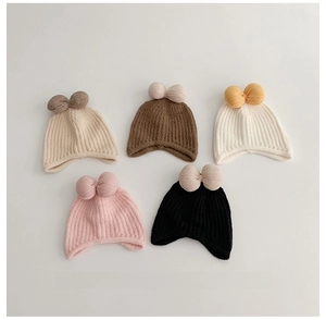 Detail of five assorted winter knit hats for baby girls featuring large plush bow accents