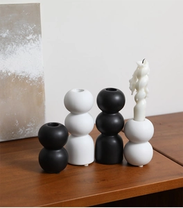 Detailed view of matte ceramic candle holders in stacked bulbous geometric shapes