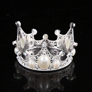 Detailed view of silver alloy crown with oval pearls and sparkling rhinestones