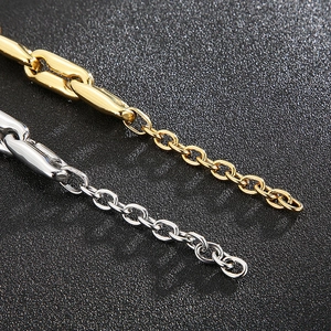 Macro shot of polished gold and silver pig nose link chains on a black textured background