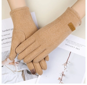 Détail du gant tricoté camel avec doigt tactile et étiquette en cuir de marque
