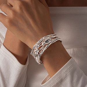 Detail of silver multi-layer wire cuff bracelet with ornate metallic floral design