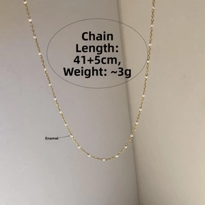Détail du collier doré avec perles en émail blanc, longueur 41+5cm et poids de 3g environ