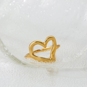 Elegant gold hollow heart ring with adjustable open design on a clean water background
