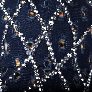 Dettaglio del cappellino in denim blu navy con strass argentati ed effetti di usura chic