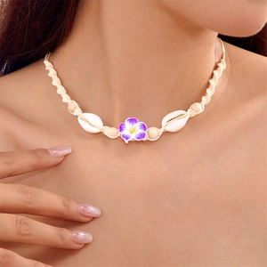 Detail of hand-woven shell necklace with purple frangipani flower for beach holiday