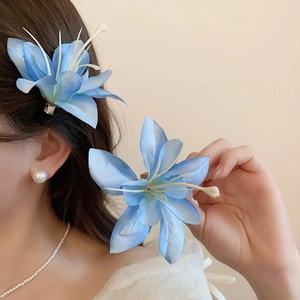 Detail of blue fabric lily hair clips showing realistic petal texture and metal duckbill base