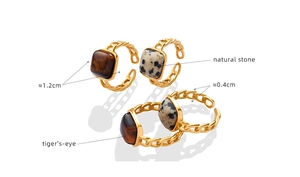 Detail of square tiger's eye and dalmatian jasper stone rings with golden chain-link band