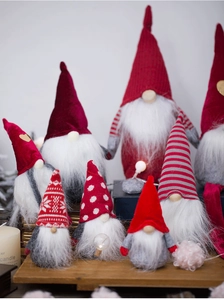 Close-up of assorted plush Christmas gnomes with knit patterns in a cozy festive setting