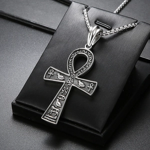 Gros plan d'un pendentif Ankh en argent avec hiéroglyphes sur un support noir