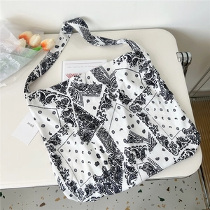 Macro detail of black and white paisley canvas tote bag with wide shoulder strap