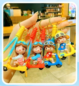 Close-up of four cute cartoon scooter keychains in yellow, red, and blue colors