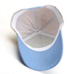 Close-up of baseball cap interior showing sewing seams, eyelets and blue plastic strap