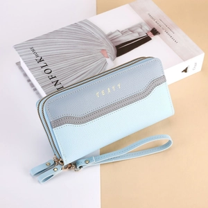Detail view of long double-zippered wallet in blue tones with lychee grain texture